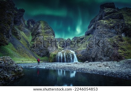 Icelandic Landscape. Scenic image of fairy-tale Stjornarfoss waterfall with Green northern lights. Waterfall at Kirkjubaejarklaustur, Southern Iceland, Europe. Incredible vivid landscape of Iceland.