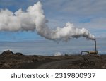 Icelandic landscape with smoking chimney of a power plant