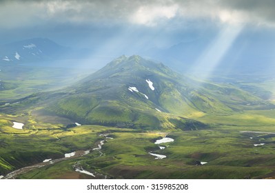 Icelandic landscape - sun shining through the clouds on a mountain at the Laugavegur hiking trail near Alftavatn on Iceland.