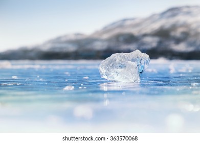 Icicle on the frozen lake. Macro image with small depth of field, bokeh effect.