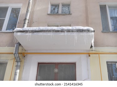 Icicles above the entrance to a residential building in Moscow. Hanging icicles above the entrance to a building, risk to life. Sharp icicles hang from the roof of an old apartment building
