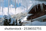 Icicles and a drop of meltwater in a rustic landscape in the sunset rays is a very close-up. Thaw and snow melting. The beginning of spring and the warm season, the end of winter. Strong macro
