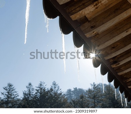 icicles at the edge of the eaves melting in the sun, SSTKHome