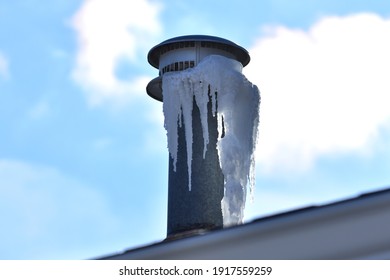 Icicles Forming On Metal Roof Vent From Moist Air In Home Coming In Contact With Very Cold Outdoor Air.