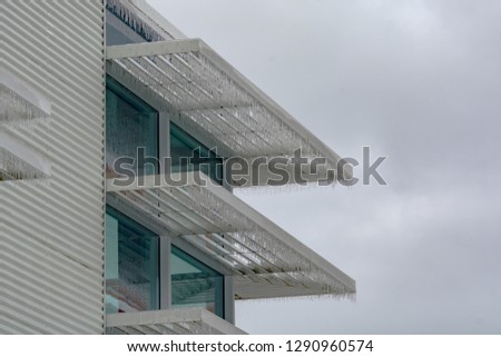 Icicles of freezing rain over window weather shelds of an office building in British Columbia, Canada