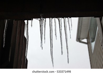icicles hanging  from a roof
 