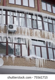 Icicles on house. Icicles on windows at winter day.