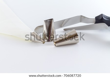 Icing tips with cream bag and cake scraper for decorating cakes and cookies with frosting isolated on white background