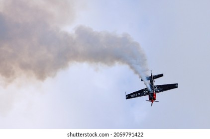 ICKWELL, BEDFORDSHIRE, ENGLAND - AUGUST 02, 2020: Extra EA-300S Stunt plane in action trailing s.moke.