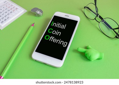 ICO initial coin offering symbol. Concept words ICO initial coin offering written on the mobile phone screen. Beautiful green background. Glasses, coin. Business ICO initial coin offering concept. Cop - Powered by Shutterstock