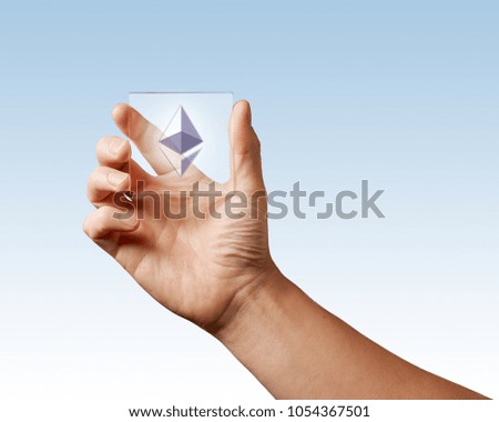 Icon of etereum on a digital screen man holds on a blue background