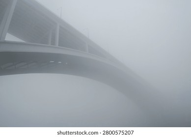Iconic Arrabida bridge over Douro river in the middle of fog, Porto, Portugal.