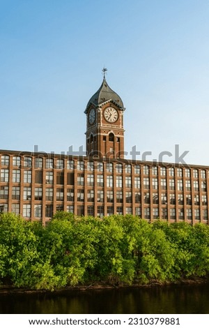 Iconic Ayer Mill clock tower and nineteenth century brick mill building in the historic immigrant city of Lawrence Massachusetts.