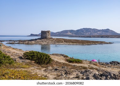 iconic beach of Stintino La Pelosa with the ancient Saracen Tower Torre del Falcone and Asinara island on the background. One of most beautiful beach in Italy. Sardinia, Sassari, Italy, Europe