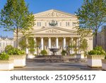 The iconic Bolshoi Theatre in Moscow, Russia, showcases its stunning neoclassical architecture under a clear blue sky.