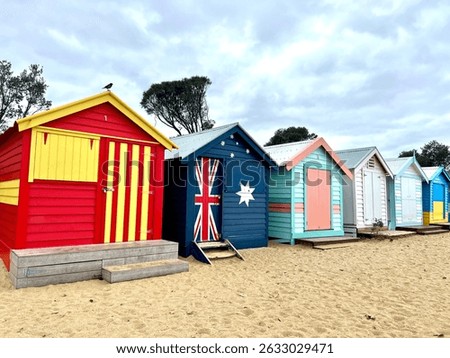 Iconic Brighton Bathing Boxes lined up along the sandy beach under a bright blue sky in Melbourne, Australia. travel content, Australian landscapes, postcards, and tourism promotion