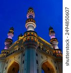 The iconic Charminar at dusk, beautifully illuminated against the twilight sky in Hyderabad, India. This captivating evening shot highlights the monument