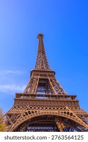 Iconic Eiffel Tower structure against a clear blue sky, a famous Parisian landmark