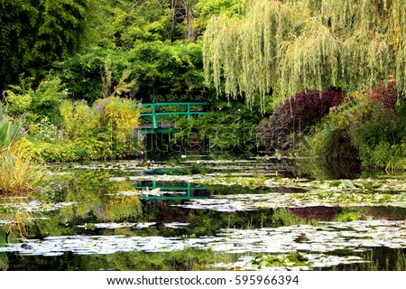 The iconic green Japanese bridge reflecting in the water lilies pond in Claude Monet's Garden of Giverny, Normandy, France