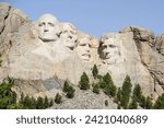 Iconic Mount Rushmore in Keystone, South Dakota, stands grand in this striking photo. Majestic granite faces carved into the Black Hills, a monumental tribute to American history and presidential lega