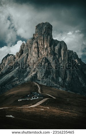 Iconic Mountain Towering Above Hiking Trail With Dark And Ominous Clouds In The Dolomites