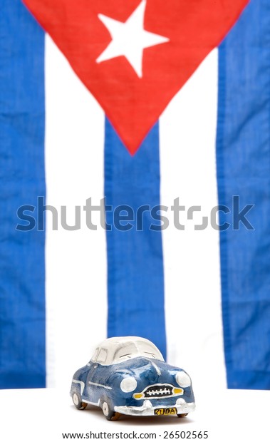 Iconic old car against the\
Cuban Flag