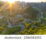 Iconic shot of the river going through the village and karst mountains in Wuzhishan Scenic Area, Cuiping Village, Grape Town, Guilin, Guangxi China, drone shot