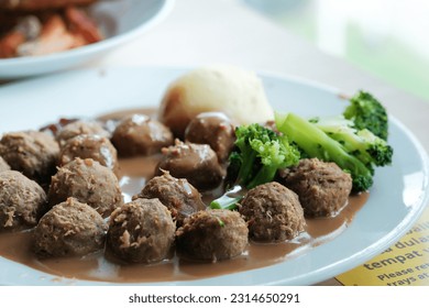 Iconic Swedish delicacy served at Ikea stores worldwide. Juicy meatballs with creamy sauce, cranberry jam, and mashed potatoes. Selective focus