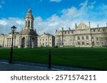Iconic Trinity College Dublin, Ireland, featuring the iconic Campanile (bell tower). Tall, freestanding structure with a large arch at its base and an ornate cupola at the top. Multi-story structure