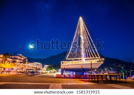 Iconic view of a decorated wooden sailing boat during Christmas period against a starry night