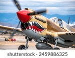 An iconic vintage World War Two fighter plane sits on the runway preparing for take off.