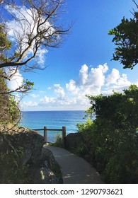 Iconic walking path through Burleigh Heads National Park with breathtaking view of Pacific ocean and white clouds on the blue sky background. 