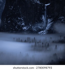 Iconic Yosemite National Park in winter, featuring El Capitan, Half Dome, and Bridalveil Fall framed by low-hanging fog and snowy pine forest at the legendary Tunnel View, California.
