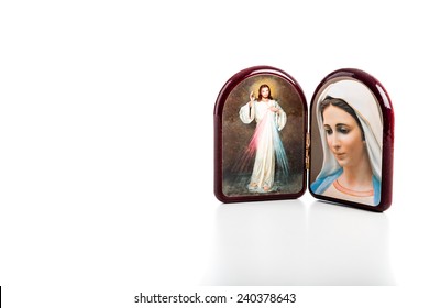 Icons in a wooden rounded case of Merciful Jesus and Our Lady of Medjugorje, the Blessed Virgin Mary isolated on white background with matte reflection on white table.