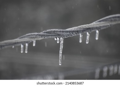 An Icy Power Line With Icicles While Snowing