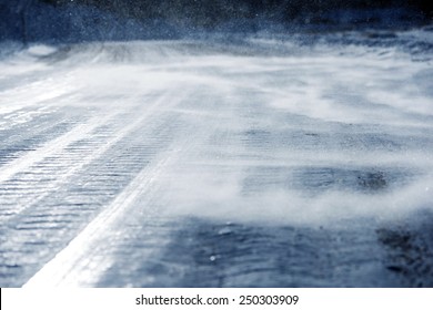 Icy Road With Drifting Snow Closeup. Dangerous Icy Road Conditions.