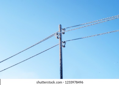 Icy Wires In The Frost On The Power Line Against The Blue Winter Sky

