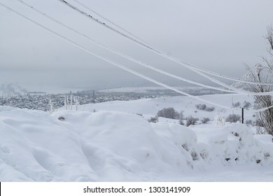 Icy Wires In The Frost On The Power Line Against The City Winter Sky