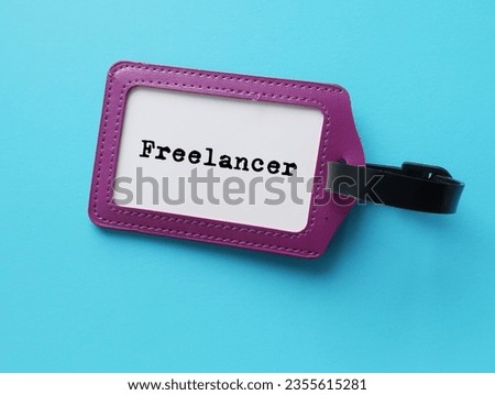 ID card holder on blue background with job title  FREELANCER - freelance worker who is self-employed, not committed to particular employer