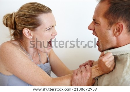 Id rather have loved and lost. Closeup of a wife grabbing her husbands shirt in anger as they fight.