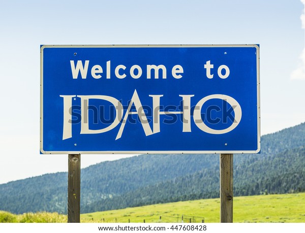 Idaho state sign in the entrance to state near\
by the freeway.