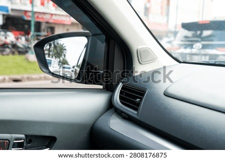 ide wing mirror reflection of a city street captured from inside a car cabin.