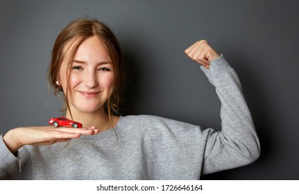 Idea And Concept For The Driving School, Learner Driver Has Passed The Test, Driving Licence, Portrait Of An Authentic And Beautiful Young Woman, Teenager Holding A Car In Her Hand