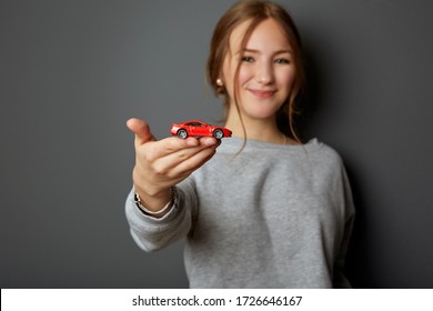 Idea And Concept For The Driving School, Learner Driver Has Passed The Test, Driving Licence, Portrait Of An Authentic And Beautiful Young Woman, Teenager Holding A Car In Her Hand