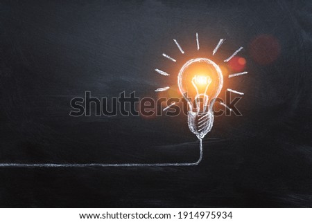 idea concept with innovation and inspiration, style symbol of creativity, brainstorm, creative idea, thinking. Lightbulb drawn by chalk representing ideas on dark background.