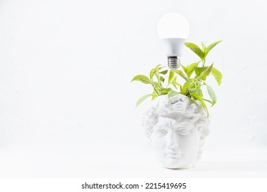 Idea Concept With Thinking Head Of Antique Statue David With Green Wreath Of Leaves As Fresh Thoughts And Glow Light Bulb Over Head, Copy Space. Brainstorming Background For Business And Work Process.