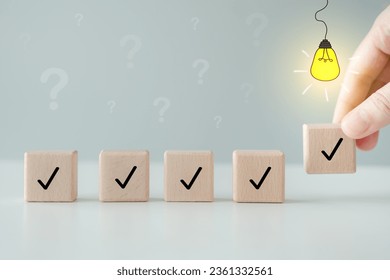 Idea and creativity concept. Creative process concept and problem solution. Hand pick check mark with glowing light bulb on top from another question mark to complete checklist for solving problem.