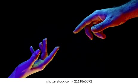 Idea earth creation  Hands reaching out  pointing finger together black   neon colorful light  Man   woman  love  religion  Contemporary art  evolution  origins concept 