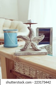 Idea Of Interior Decor In Beach Cottage Style With Trendy Glass Candlestick And Rustic Photo Frame.