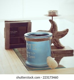 Idea Of Interior Decor In Beach Cottage Style With Trendy Glass Candlestick And Rustic Photo Frame.